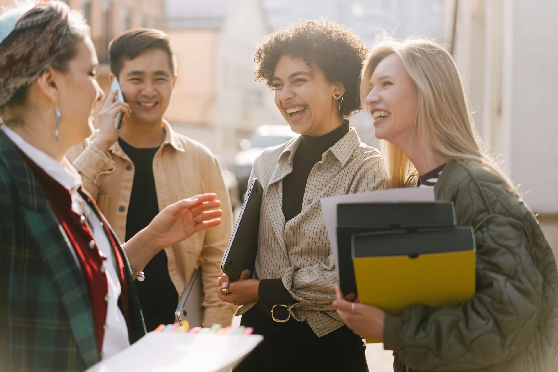 Grupo diverso de adultos sorrindo e conversando ao ar livre